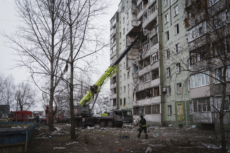 Rescue workers clearing rubble from a damaged residential building.