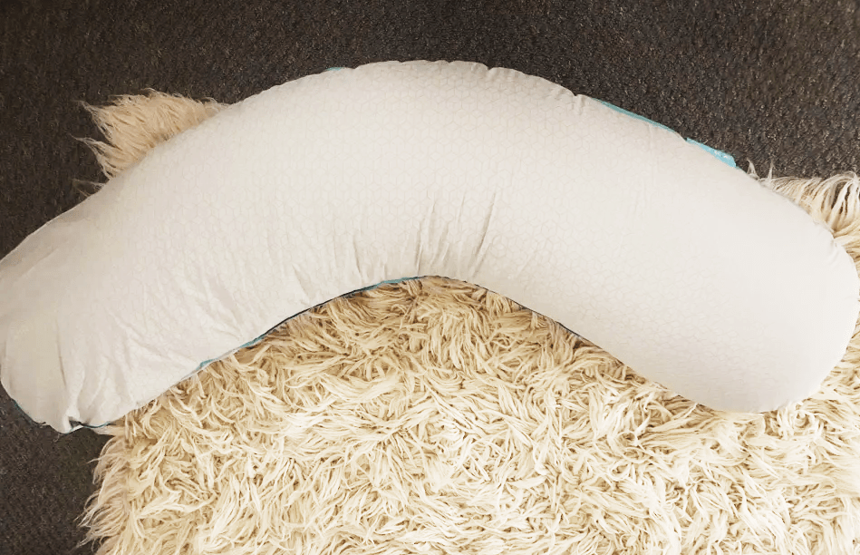 U-shaped body pillow on a fluffy rug.
