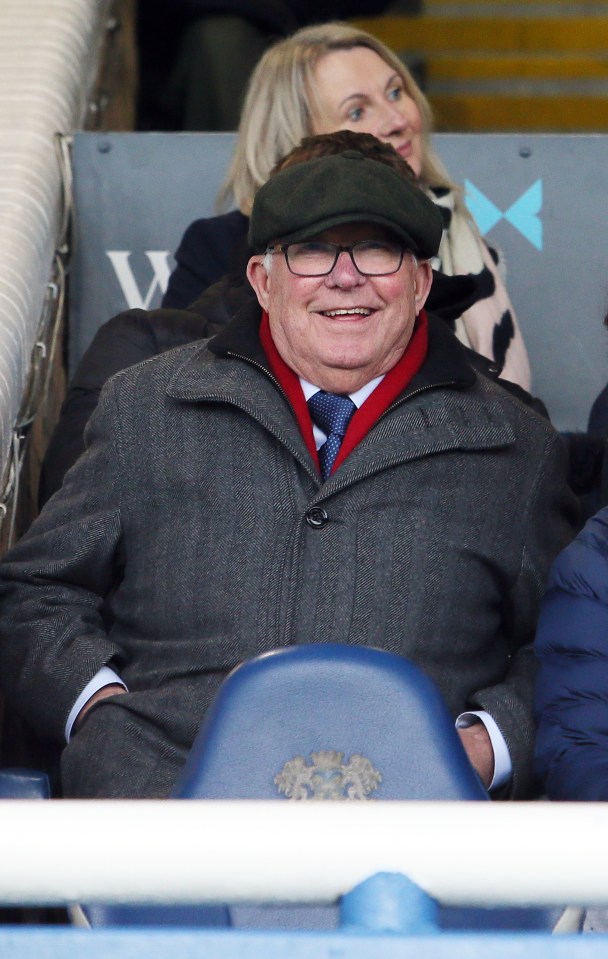 Sir Alex Ferguson watching a football match from the stands.