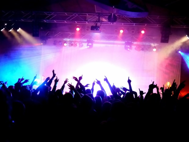 Crowd at a rock concert with hands raised.