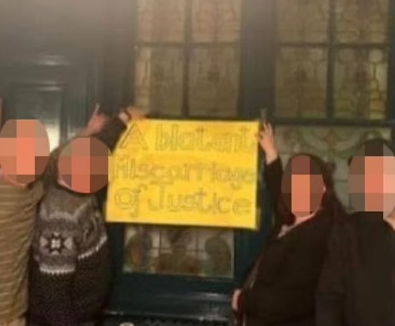 People holding a sign that reads "A blatant miscarriage of justice."