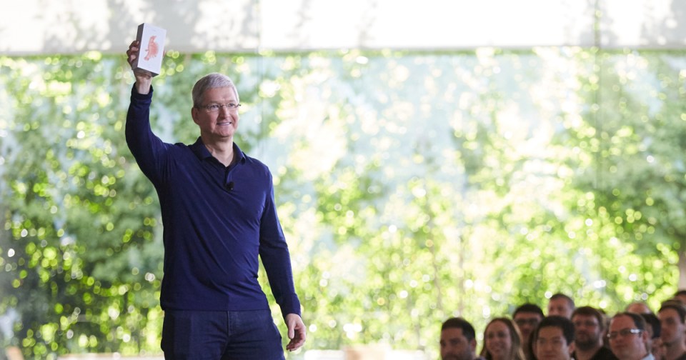 Tim Cook holding up a product box.