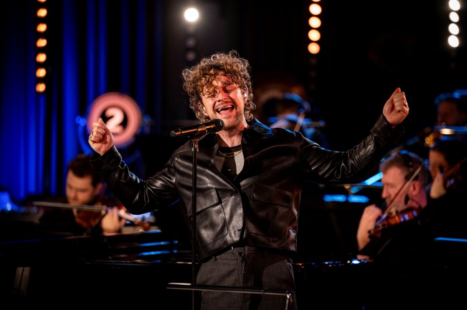 Tom Grennan performing with an orchestra.