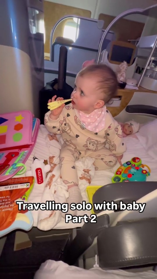 Baby eating snack on airplane.