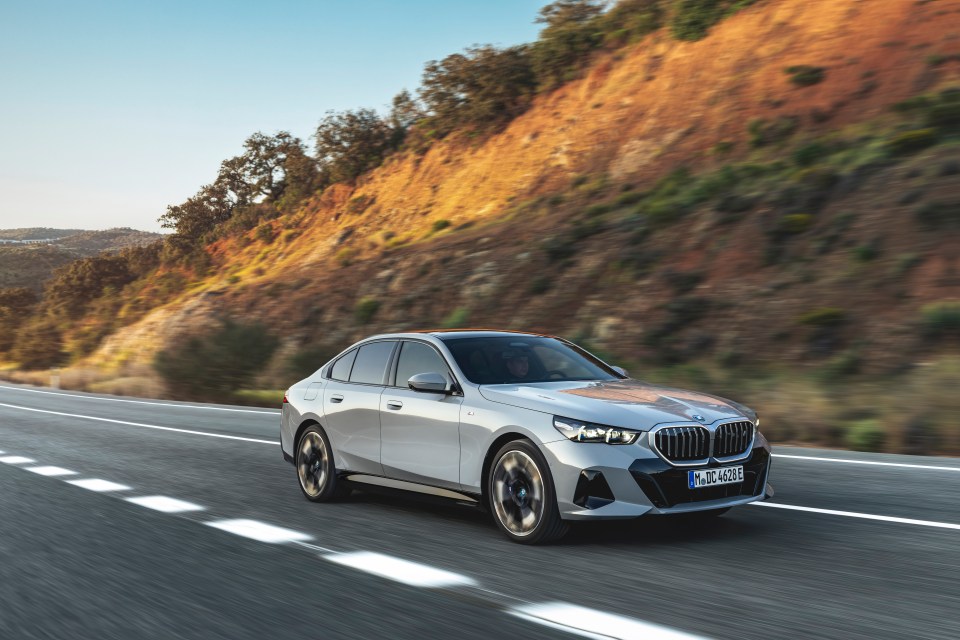 The new BMW 5 Series Sedan driving on a highway.