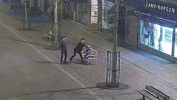 Nighttime security camera footage showing two people damaging and stealing a Paddington Bear statue.