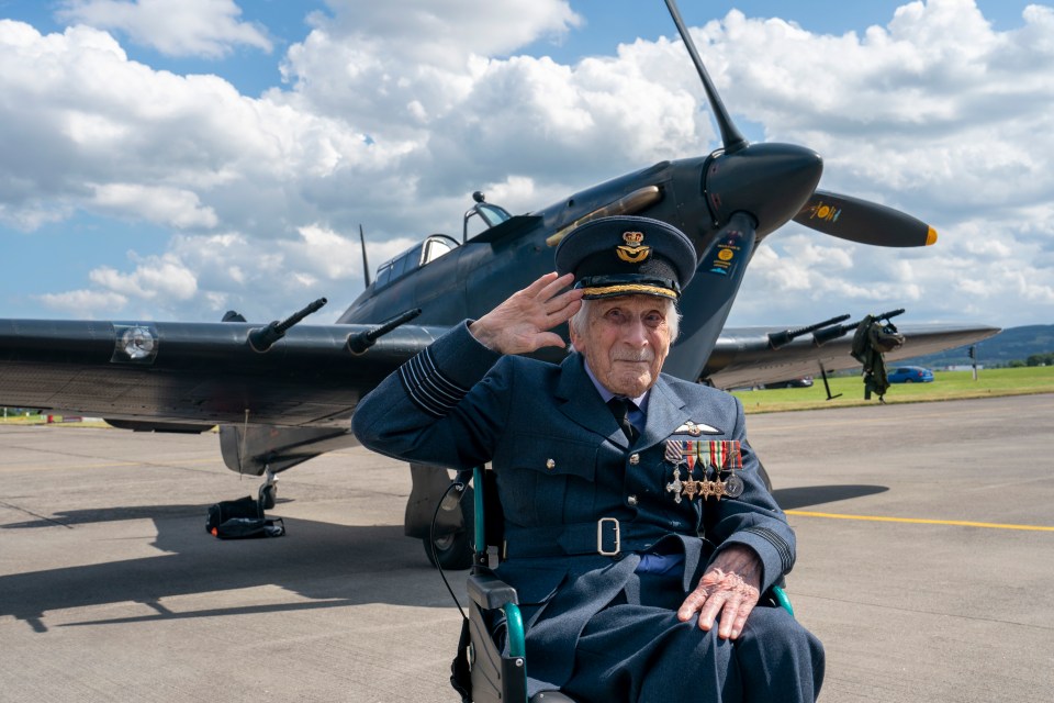 World War II veteran saluting in front of a Hawker Hurricane.