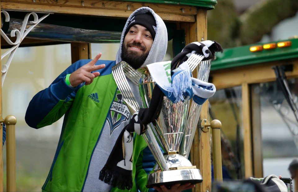 Clint Dempsey holding the MLS Cup trophy during a championship parade.