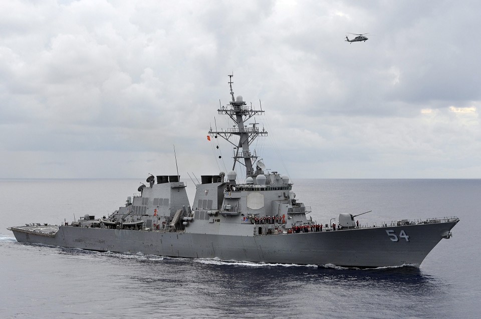 USS Curtis Wilbur guided-missile destroyer at sea with helicopter overhead.