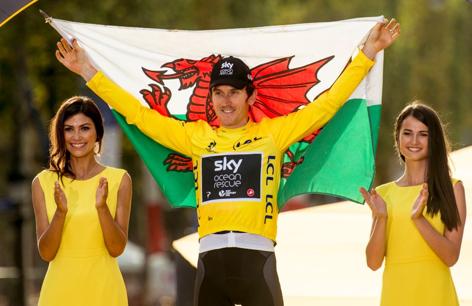 Geraint Thomas holding a Welsh flag, flanked by two women in yellow dresses.