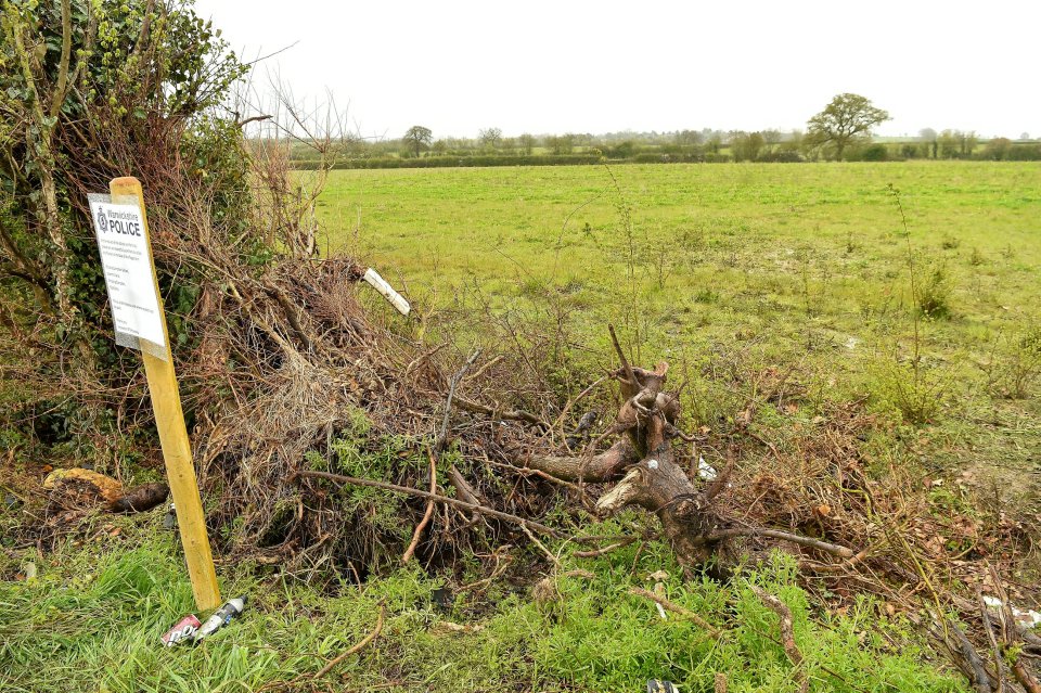 A roadside memorial with a police notice.