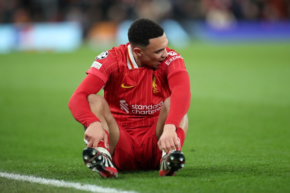 Trent Alexander-Arnold of Liverpool sitting on the field, appearing injured.