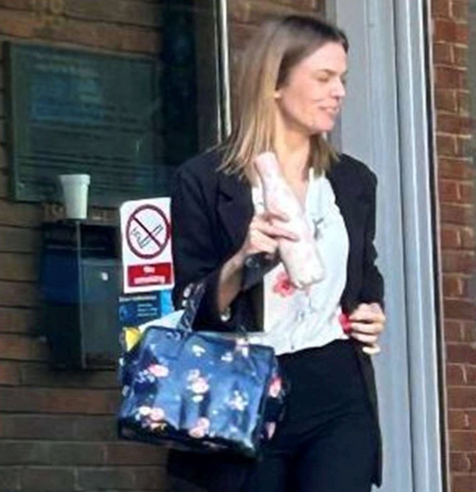Woman leaving court holding a handbag and bottle.