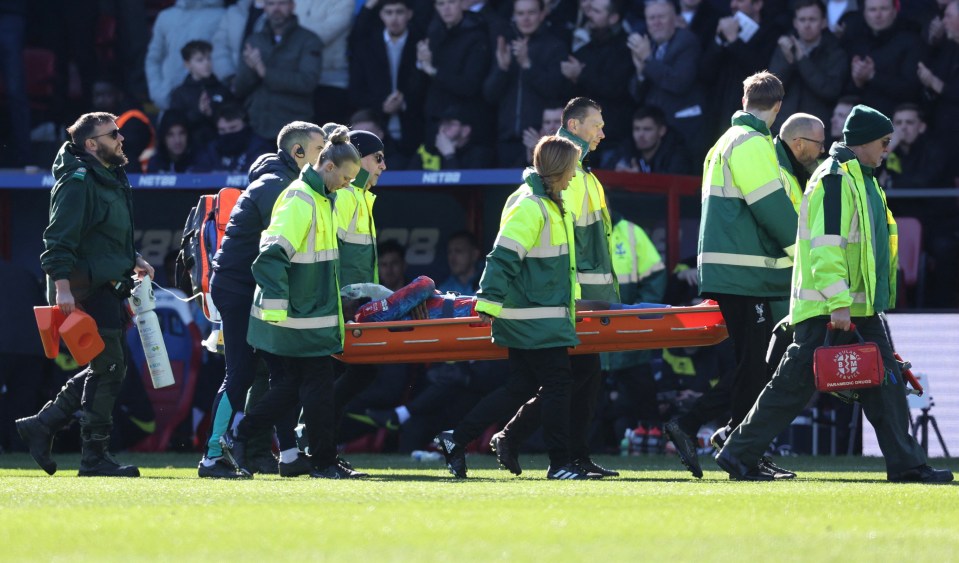 Injured soccer player being carried off the field on a stretcher.