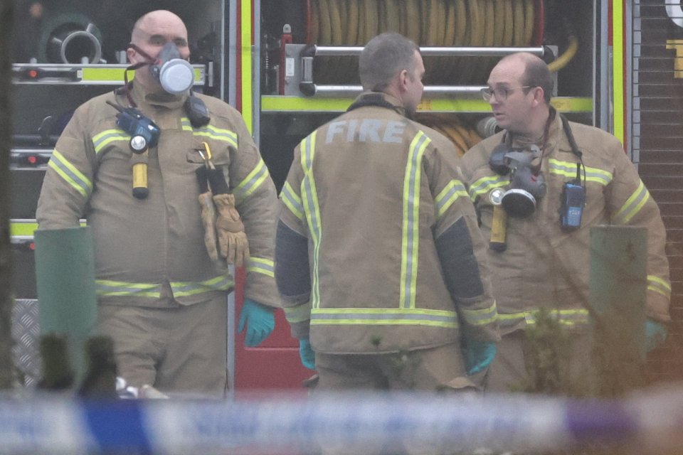 Firefighters in protective gear at a fire scene.