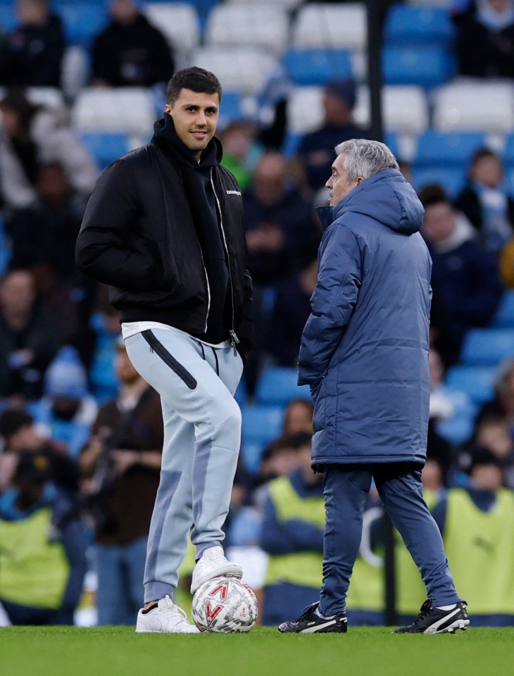 Manchester City's Rodri and a coach before a match.