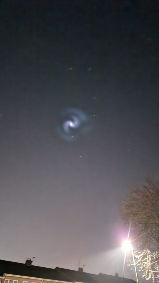 Spiral of illuminated frozen fuel from a SpaceX rocket launch seen in the night sky above the UK.