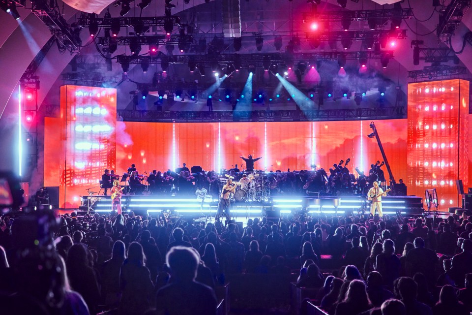 Imagine Dragons performing live with an orchestra.