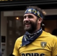 A Leeds United fan smiling.