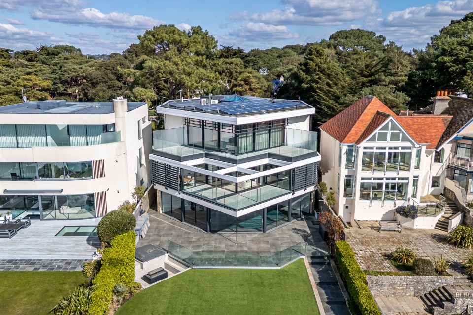 Aerial view of a modern waterfront mansion.