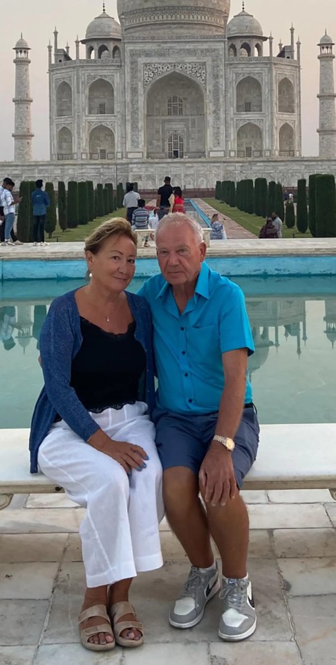 Couple sitting in front of the Taj Mahal.