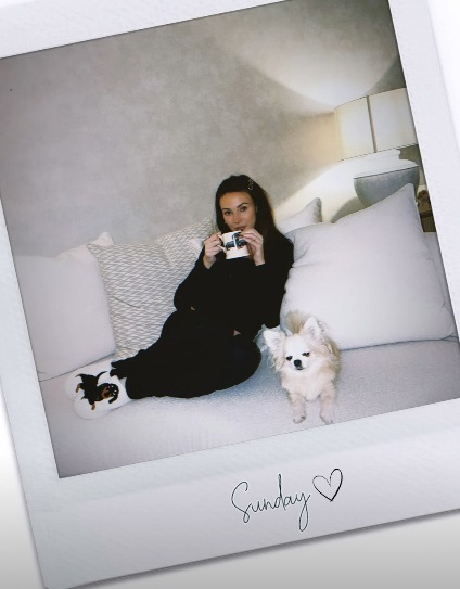 Michelle Keegan's Instagram post: a woman relaxing on a couch with a dog.