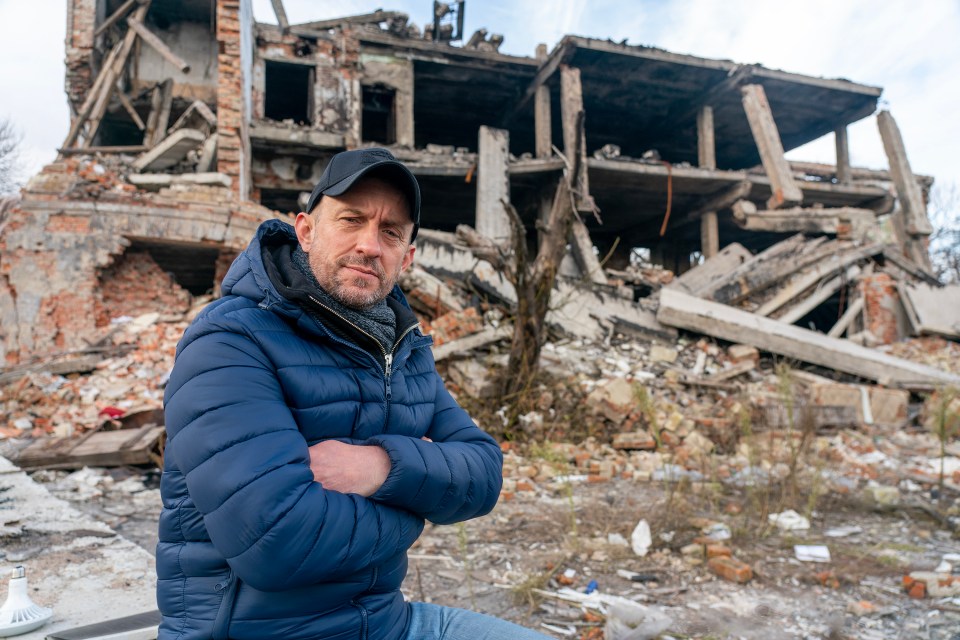 Former British soldier Shaun Pinner in front of a destroyed building.