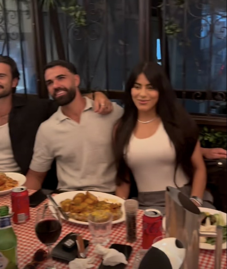 Three people sitting at a table eating.