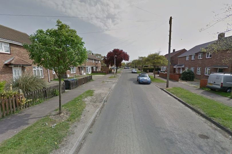 Residential street with houses and cars.