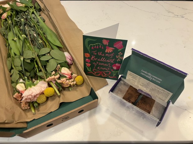 Flowers, card, and brownies on a counter.