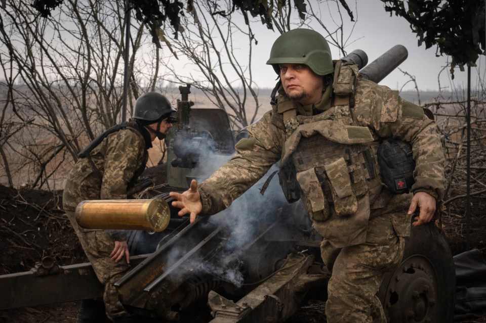 Ukrainian soldiers firing a howitzer.