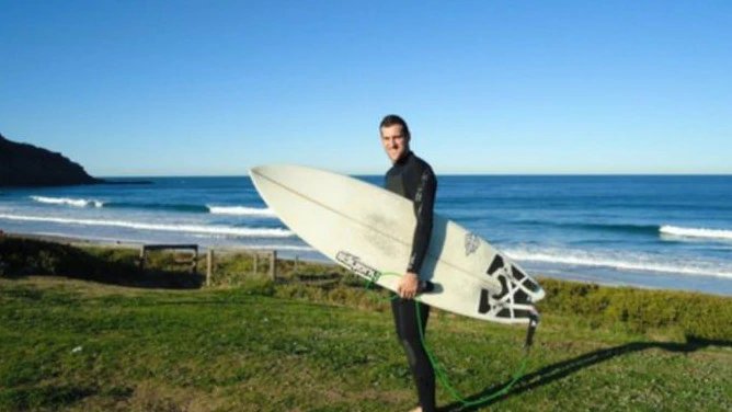 Man holding surfboard at the beach.