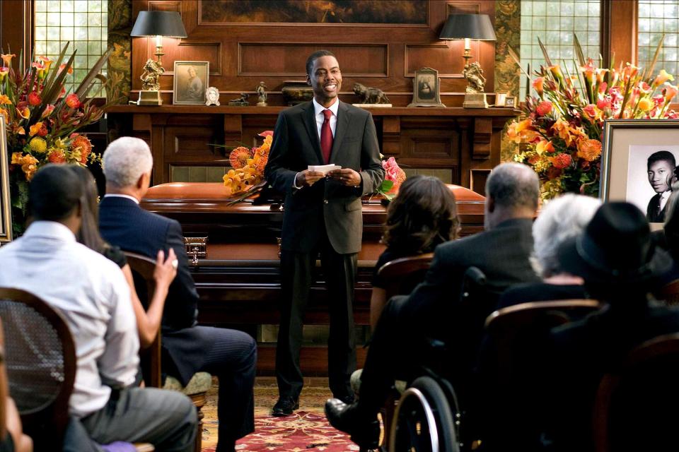 Chris Rock giving a eulogy at a funeral.