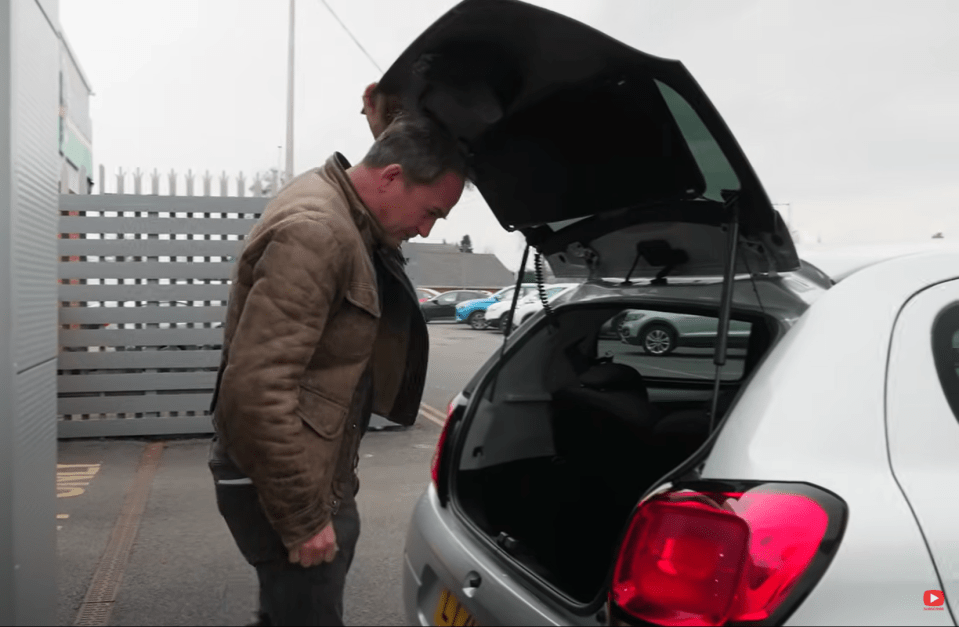 Man opening the trunk of a car.