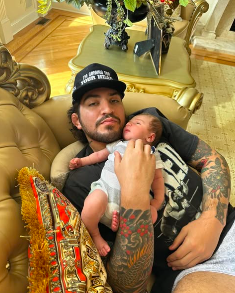 Man holding a baby on a couch.