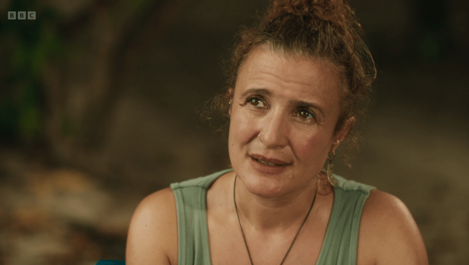 Screenshot of a woman looking up and to the side.