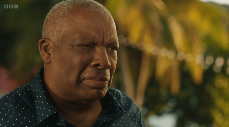 Screenshot of a man looking pensive.
