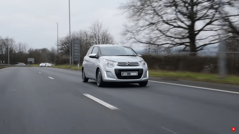 Silver car driving on a highway.
