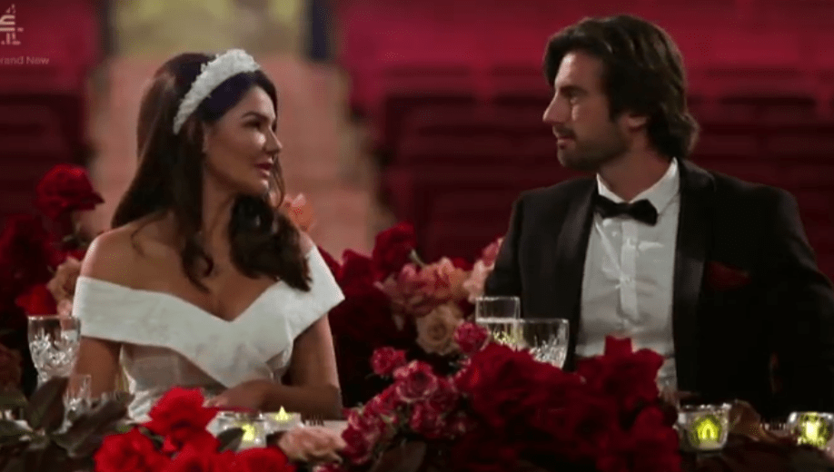 Screenshot of a bride and groom seated at their wedding reception.
