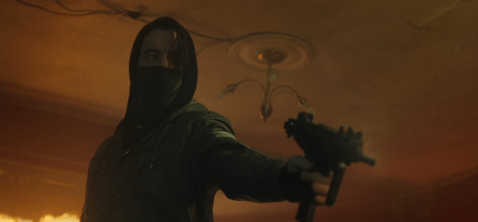 Masked person aiming a gun in a smoky room.