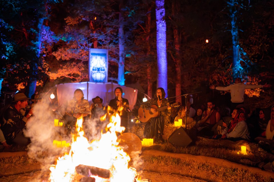 A musical performance around a bonfire at night.
