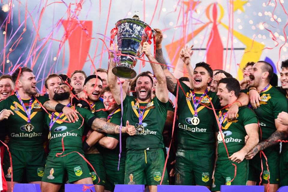Australian rugby league team celebrating victory with trophy.