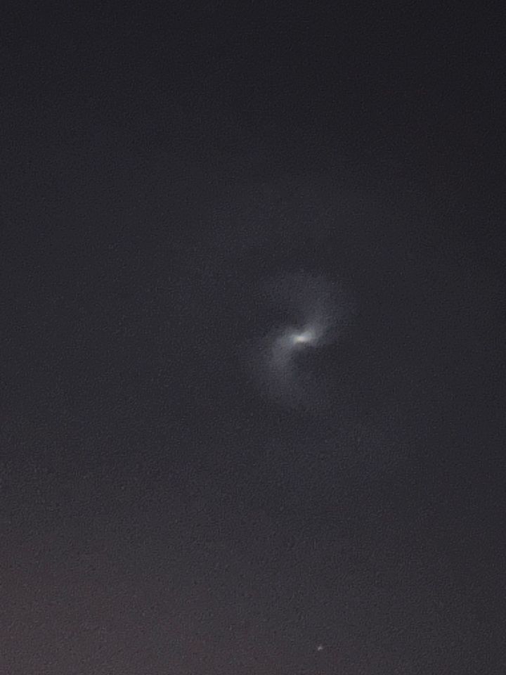 Spiral of illuminated frozen fuel expelled from a SpaceX rocket.