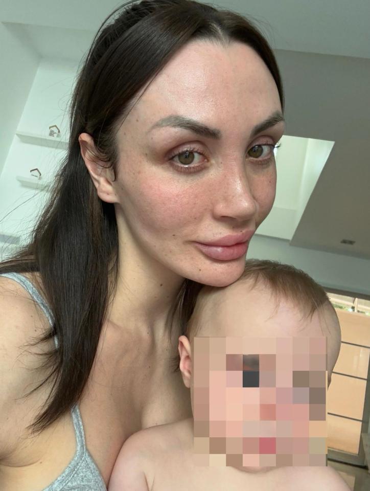 Woman holding a baby; baby's face is pixelated.