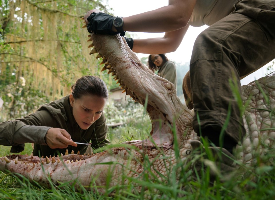 Natalie Portman examining a creature's head in *Annihilation*.