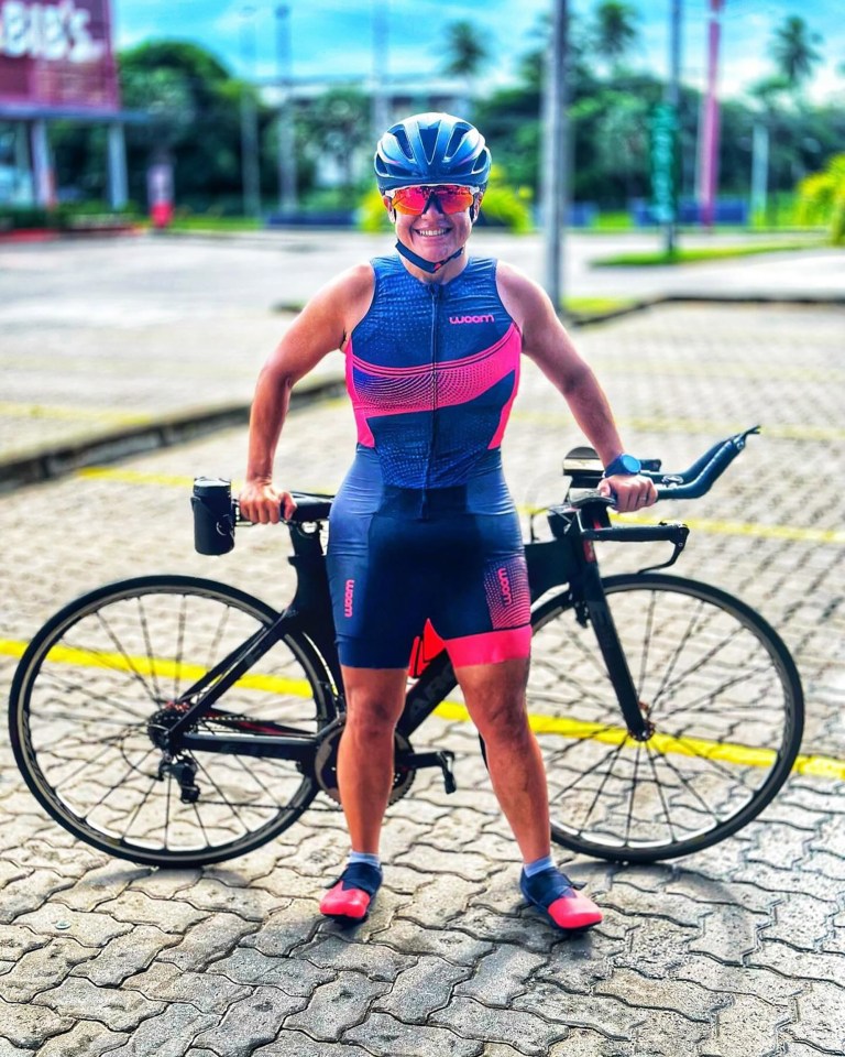 Woman in cycling gear standing with her bicycle.
