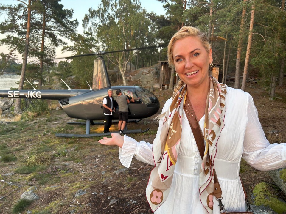 Woman in white dress standing in front of a helicopter.
