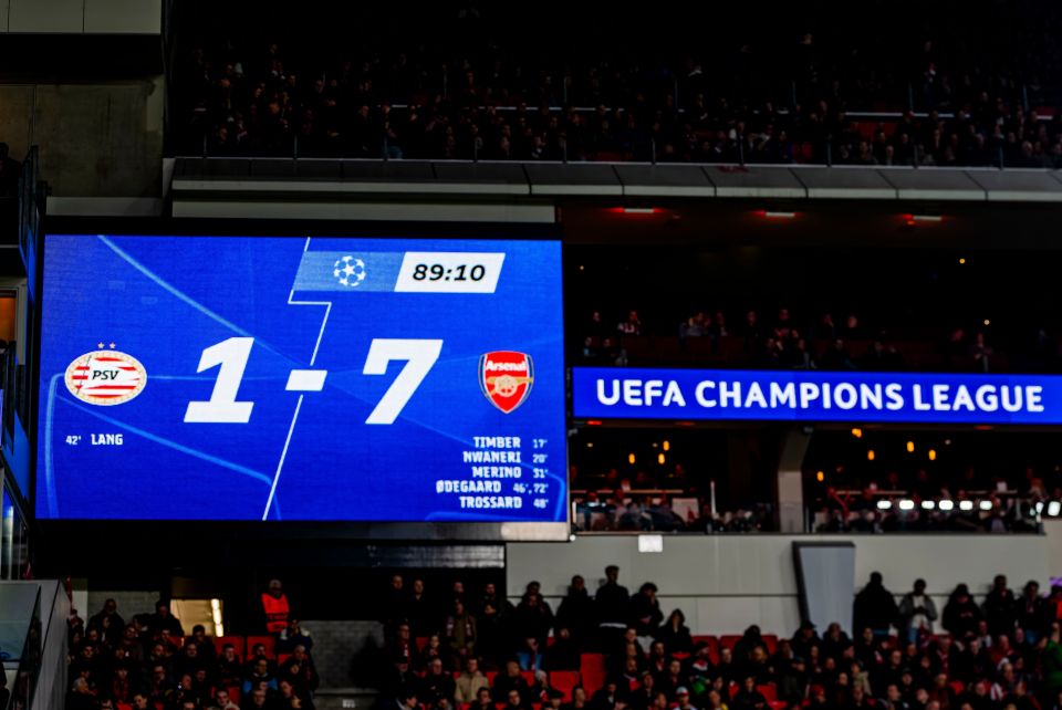 Stadium scoreboard showing PSV 1-7 Arsenal in the UEFA Champions League.