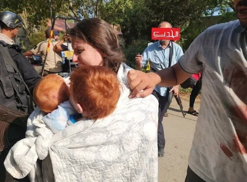 A woman holding two young children, who are missing along with their father.
