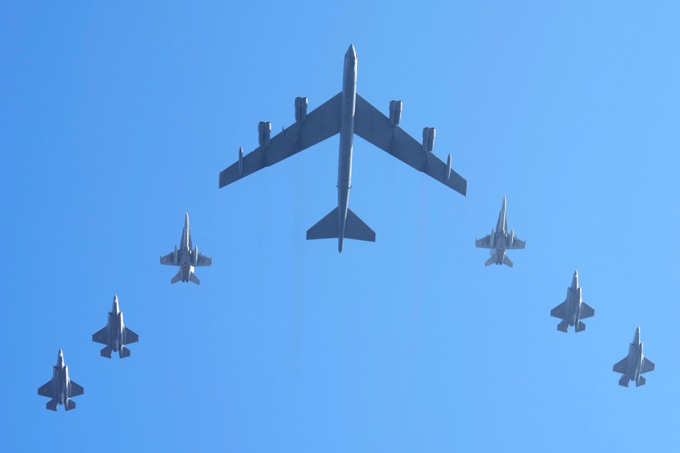 B-52 bomber flanked by F-35 and F-18 jets.